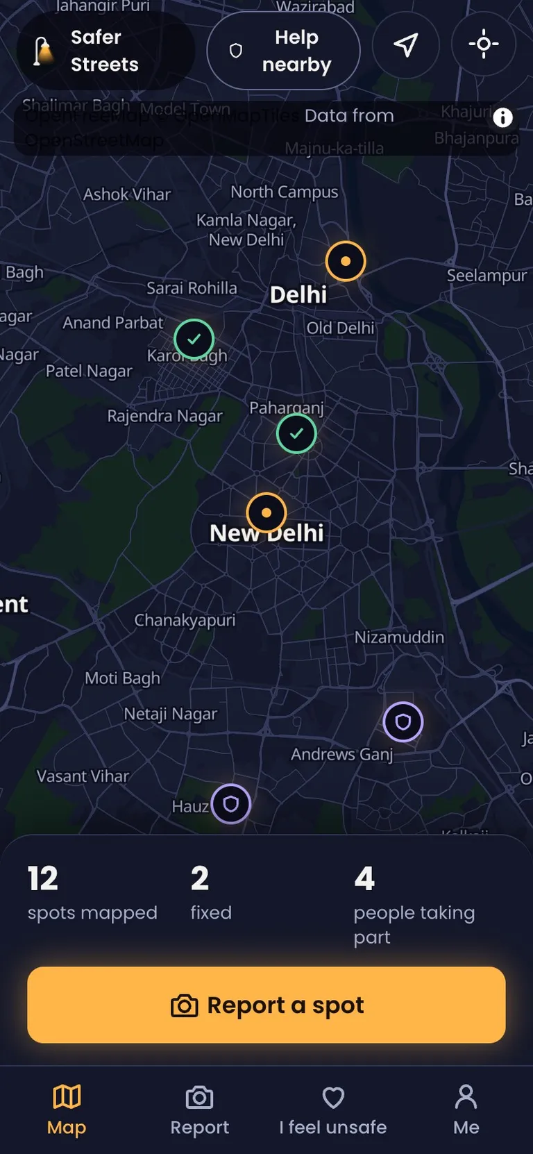 The Safer Streets app on a phone: a night map of Delhi with reported and fixed spots, and a Report a spot button